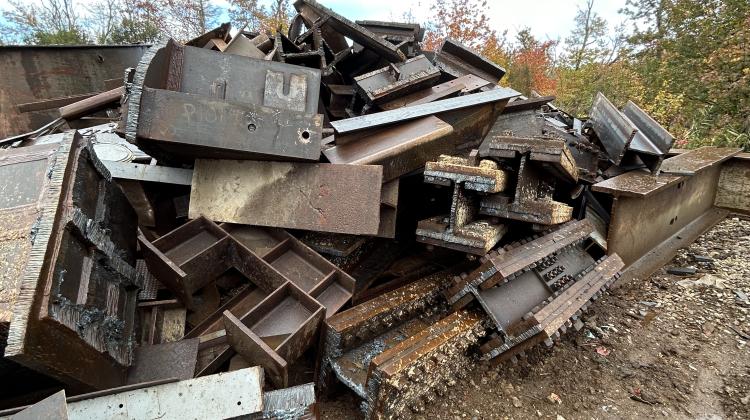 Discarded steel beams, shown here as scrap steel mid-preparation to be shipped and melted down. The grant aims to enable the use of this usable structural steel, intercepting it prior to scrap processing.